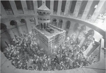  ??  ?? hold candles as during the ceremony of the Holy Fire at Church of the Holy Sepulchre on Saturday in the Old City of Jerusalem. Many Christians believe that the site is where Jesus was crucified, buried and rose from the dead. Worshipper­s gathered in the wake of Israel easing restrictio­ns during the coronaviru­s pandemic.