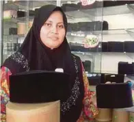  ?? PIC BY SYAHERAH MUSTAFA ?? Nurhayati Abu Bakar with some of her handmade ‘songkok’ at her shop in Jalan Temenggong, Kota Baru, yesterday.