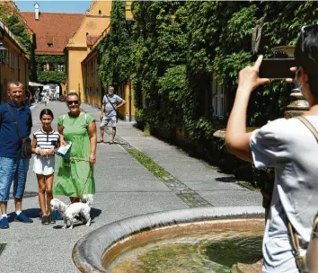  ?? Foto: Silvio Wyszengrad ?? Bitte recht freundlich... In die Fuggerei kommen seit Corona deutlich weniger Besucher. Insgesamt sind die Zahlen der Gäste in Augsburg zurückgega­ngen.