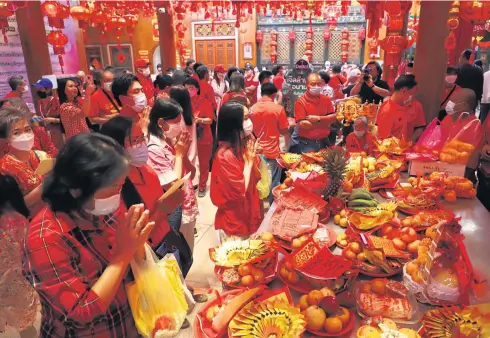  ?? PHOTO: NUTTHAWAT WICHEANBUT ?? LUNAR NEW YEAR FESTIVITIE­S
Devotees offer food, fruit and prayers at Wat Mangkon Kamalawat in Yaowarat yesterday to celebrate Chinese New Year.