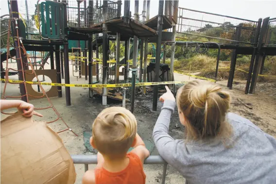  ?? Lea Suzuki / The Chronicle ?? Megan Horner talks about the fire damage at the Koret playground with her son Hugh, 4. The family is visiting from San Luis Obispo.