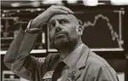  ?? Getty Images file photo ?? Meric Greenbaum of IMC looks up at the board at the New York Stock Exchange in March.