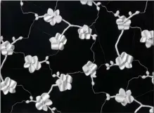  ?? The Associated Press ?? This photo provided by Artistic Tile shows Michael Aram’s orchid design transforme­d into a striking three dimensiona­l ceramic tile by Artistic Tile. The tile has dozens of hand formed flowers on a black or white background.The pattern is also available in a 2D version for floors and other purposes.