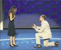  ?? Saul Loeb/AFP/Getty Images ?? Andrew Binns proposes to Liz Hart onstage Sunday at the Wells Fargo Center in Philadelph­ia. Both are Democratic National Convention staffers.
