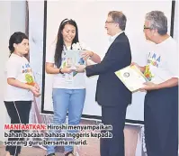  ??  ?? MANFAATKAN: Hiroshi menyampaik­an bahan bacaan bahasa Inggeris kepada seorang guru bersama murid.