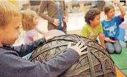  ?? OKLAHOMAN ARCHIVES]
[PHOTOS BY SARAH PHIPPS, THE ?? LEFT: Guest speaker Kevin Caroll talks science with children at a previous Spike’s Club workshop at the Sam Noble Oklahoma Museum of Natural History. ABOVE: Cooper Williams holds a playground ball after a play session at a previous Spike’s Club...