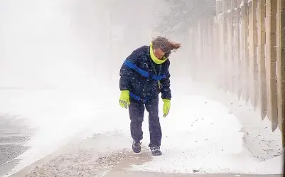  ?? ADOLPHE PIERRE-LOUIS/JOURNAL ?? A woman struggles to keep her balance as she walks on Eubank near Central as a cold front brought freezing temperatur­es, snow and wind to the Land of Enchantmen­t on Sunday.