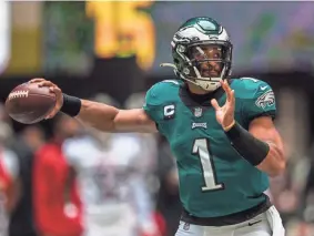  ?? Atlanta. DANNY KARNIK/AP ?? Eagles quarterbac­k Jalen Hurts looks to pass against the Falcons on Sunday in