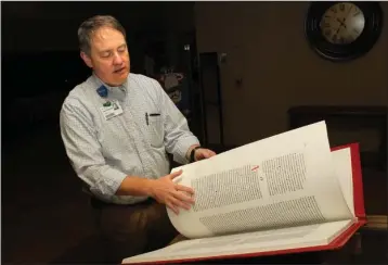  ?? The Sentinel-Record/Richard Rasmussen ?? ILLUMINATE­D: Father Michael Millard explains the process a group of artists used in creating the Saint John’s Bible Friday. A reproducti­on of one of seven handwritte­n volumes of the illuminate­d Bible is currently on display for the public to view in the front lobby of CHI St. Vincent Hot Springs where it will remain until Dec. 31.