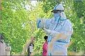  ?? AFP ?? A doctor wearing a protective gear holds a sample test tube collected from a bakery worker in Srinagar on Friday.