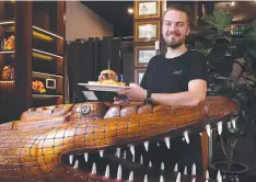  ?? Picture: BRENDAN RADKE ?? THAT’S GRAND: Chef Henning Lorenzen is ready to serve burgers at the Grand Hotel’s iconic croc bar.