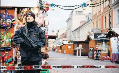  ?? SEBASTIAN GABSCH / EFE ?? Vigilància policial entre casetes buides al mercat de Potsdam, desallotja­t ahir a la tarda per seguretat