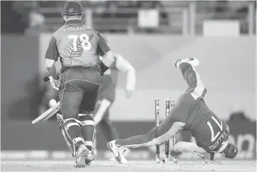  ??  ?? South Africa’s captain AB de Villiers tumbles over the stumps during a failed run out attempt on New Zealand’s batsman Corey Anderson during their Cricket World Cup semi-final match in Auckland in this March 24 file photo. — Reuters photo