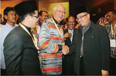  ??  ?? Light moment: Najib shaking hands with former Perlis mufti Dr Mohd Asri while the current mufti Dr Juanda Jaya (left) looks on at PWTC yesterday.