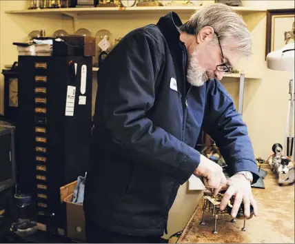  ?? Photos by Paul Buckowski / Times Union ?? James Dunbrook,a freelance horologist at The Clock Works, repairs a time and strike movement for a calendar clock at the shop n Schenectad­y.