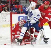  ?? PAUL SANCYA, THE ASSOCIATED PRESS ?? Detroit Red Wings goalie Jimmy Howard stops a shot as defenceman Jonathan Ericsson Toronto’s left wing Matt Martin.