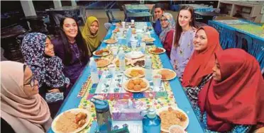  ?? PIC
BY NAZIRUL ROSELAN ?? Kendall Iaquinta (third from left) and Nicole Charette (third from right) breaking fast with Sekolah Menengah Kebangsaan (SMK) Jengka 16 students in Maran yesterday.