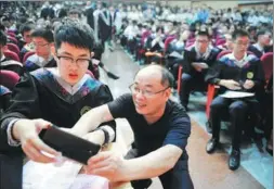  ??  ?? The father of a student at the School of the Gifted Young prepares to record his son’s speech.