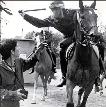  ??  ?? Flashpoint: A mounted policeman swings his baton during the clash with miners at Orgreave