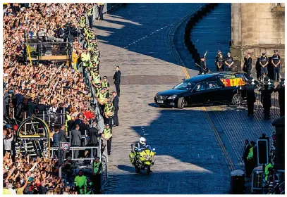  ?? ?? Flying home: The Queen’s coffin is carried aboard at Edinburgh airport. Inset: Crowds on Scottish capital’s Royal Mile