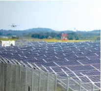  ?? STAFF FILE PHOTO ?? An airplane flies into Chattanoog­a Metropolit­an Airport, in the background, as part of Lovell Field’s solar farm is seen near the runway. Officials say the airport may soon be the nation’s first to be completely powered by solar power.