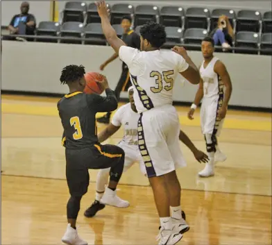  ?? Terrance Armstard/News-Times ?? Defense: Junction City's Charles Hoof (35) and Hishmma Taylor (24) guard Harmony Grove's Xaylon Falls (3) during their contest at the Hampton Holiday Classic earlier this season. Junction City hosts Warren tonight.