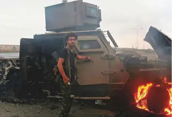  ?? AFP ?? An Al Houthi rebel inspects a burnt armoured vehicle on Thursday, reportedly destroyed in an air strike during clashes between fighters loyal to President Abd Rabbo Mansour Hadi and Al Houthis.