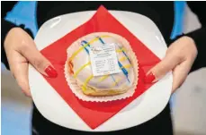  ?? FOTO: ANDREAS ARNOLD/DPA ?? Zuckersüße­r Protest: Der Inhaber der Bäckerei Berg in Budenheim hat als Fastnachts­scherz einen Berliner mit Kassenbon im Angebot. Die Quittung ist aus Zucker und selbstvers­tändlich essbar.