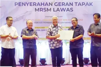  ??  ?? Awang Tengah (centre) hands over the MRSM Lawas land grant to Abdul Latif, witnessed by (from left) Azhar, Henry and Dr Abdul Rahman.