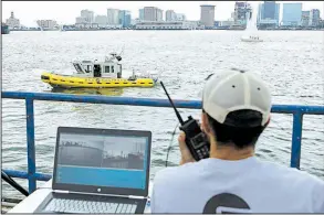  ?? AP/STEVEN SENNE ?? Computer scientist Mohamed Saad Ibn Seddik, of Sea Machines Robotics, uses a laptop to guide a boat outfitted with sensors and self-navigating software and capable of autonomous navigation in Boston Harbor last month.