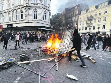  ?? Armando Babani European Pressphoto Agency ?? PROTESTERS ERECT burning barricades in Hamburg’s St. Pauli district. At least 11 protesters were seriously injured Friday.