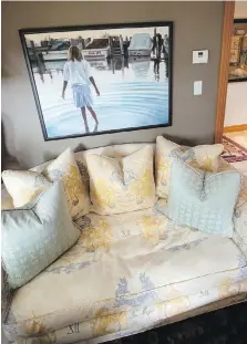  ??  ?? Japanese motif upholstery covers pale living room sofas, along with soft turquoise cushions with calligraph­y patterns. A Portland artist’s painting of a girl creating ripples adds brightness to the dark olive wall.