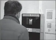  ?? AP/NG HAN GUAN ?? A man tries out a facial-recognitio­n toilet-paper dispenser at a restroom in the Temple of Heaven park in Beijing in late March.