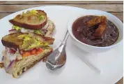  ??  ?? Vinaigrett­e’s hot turkey sandwich with a bowl of mushroom stew.