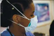  ?? PHOTO BY ROBERT NICKELSBER­G — GETTY IMAGES ?? A nurse wearing a N-95mask, listens as a doctor discusses the vital signs of a COVID-19 patient with his medical staff on the Intensive Care Unit (ICU) floor at the Veterans Affairs Medical Center on April 21 in the Brooklyn borough of New York City.