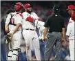  ?? MATT SLOCUM - THE ASSOCIATED PRESS ?? Phillies reliever Jose Alvarado, second from left, wipes rosin off his right arm as umpire Phil Cuzzi, center, and several others look on Tuesday night at Citizens Bank Park.