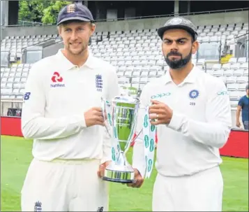  ??  ?? India skipper Virat Kohli (R) and England captain Joe Root pose with the trophy of the five-match Test series.