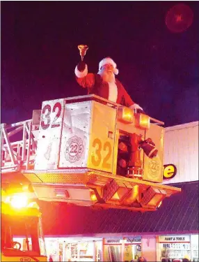  ?? Photo by Randy Moll ?? Santa greeted parade-goers from the bucket of a firetruck during the annual Gentry Chamber of Commerce Christmas Parade on Saturday.