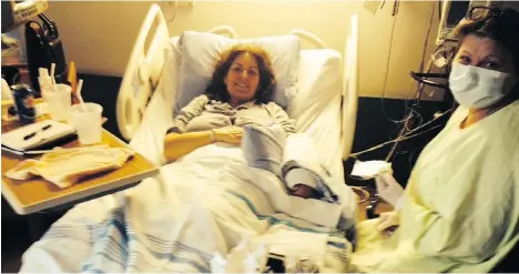  ??  ?? Licia Corbella lies in a hospital bed in isolation at Rockyview Hospital with nurse Sherolyn while she was undergoing breast cancer treatment. She describes this photo as “leading into one of the worst nights of my life.”