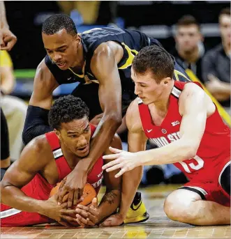  ?? CHARLIE NEIBERGALL / AP ?? OSU’s Musa Jallow (left) and Andrew Dakich go for a loose ball Thursday at Iowa. “I don’t think anyone expected him to play as well as he has for us,” coach Chris Holtmann said about Dakich.