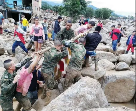  ?? COLOMBIAN ARMY PHOTO VIA THE ASSOCIATED PRESS ?? Colombian soldiers and residents work together in rescue efforts in Mocoa, Colombia, on Saturday after an avalanche of water from three overflowin­g rivers swept through the city as people slept. The incident was triggered by intense rains that left at...