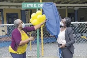  ??  ?? Acting principal of Titchfield High School in Port Antonio, Portland, Sheryl Horne-mair (right), and board member, Elaine Williams, unveil the newly erected sign for the Lloyd O Chin Drive, on the institutio­n’s campus, following the ribbon-cutting ceremony on November 11.