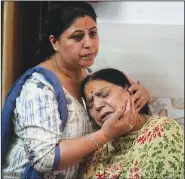  ?? ?? Rattna Pandita is consoled by her daughter Rohini as she mourns June 14 for her son Ajay Pandita Bharti, a Kashmiri Hindu village head who was shot dead in Kashmir, at their residence in Jammu.