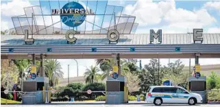  ?? JOE BURBANK/ORLANDO SENTINEL ?? ABOVE: A guard is posted at the parking turnstile to Universal Orlando on March 17. The theme park has extended its shutdown through “at least” May 31.