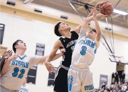  ?? ROBERTO E. ROSALES/JOURNAL ?? Terrin Dickey of Volcano Vista, center, rejects a shot by Cleveland’s Even Gonzales during the Metro final Saturday night at Volcano Vista. At left is the Storm’s Joshua Tarry, who had 20 points in his team’s 71-70 victory.