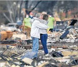  ??  ?? “IT’S HARD to find somebody you don’t know” who has been affected by the fires, Press Democrat photograph­er Kent Porter said. Above, Gordon Easter and his fiancee, Gail Hale, return to the remains of their Santa Rosa home last week.