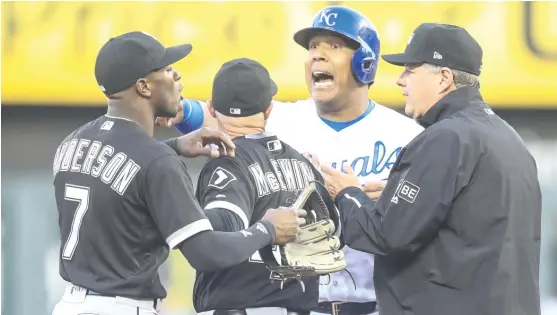  ?? GETTY IMAGES ?? Sox bench coach Joe McEwing keeps shortstop Tim Anderson and Royals catcher Salvador Perez apart during the first inning of Game 2 of a doublehead­er Saturday.