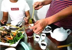  ??  ?? A diner preparing a drink of rice wine mixed with snake blood at the restaurant.