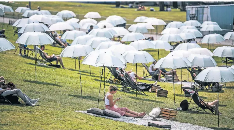  ?? FOTO: ANDREAS BRETZ ?? Der bis jetzt heißeste Tag des Jahres ließ sich nur im Wasser oder im Schatten aushalten. Am Düsseldorf­er Stadtstran­d waren alle Sonnenschi­rme aufgespann­t.