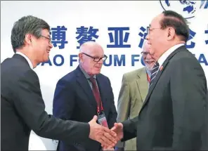  ?? WANG ZHUANGFEI / CHINA DAILY ?? Li Ruogu (right), former chairman of the Export-Import Bank of China, shakes hands with Ryozo Himino, vice-minister for internatio­nal affairs of the Financial Services Agency of Japan, after a seminar of the Boao Forum for Asia on Friday.